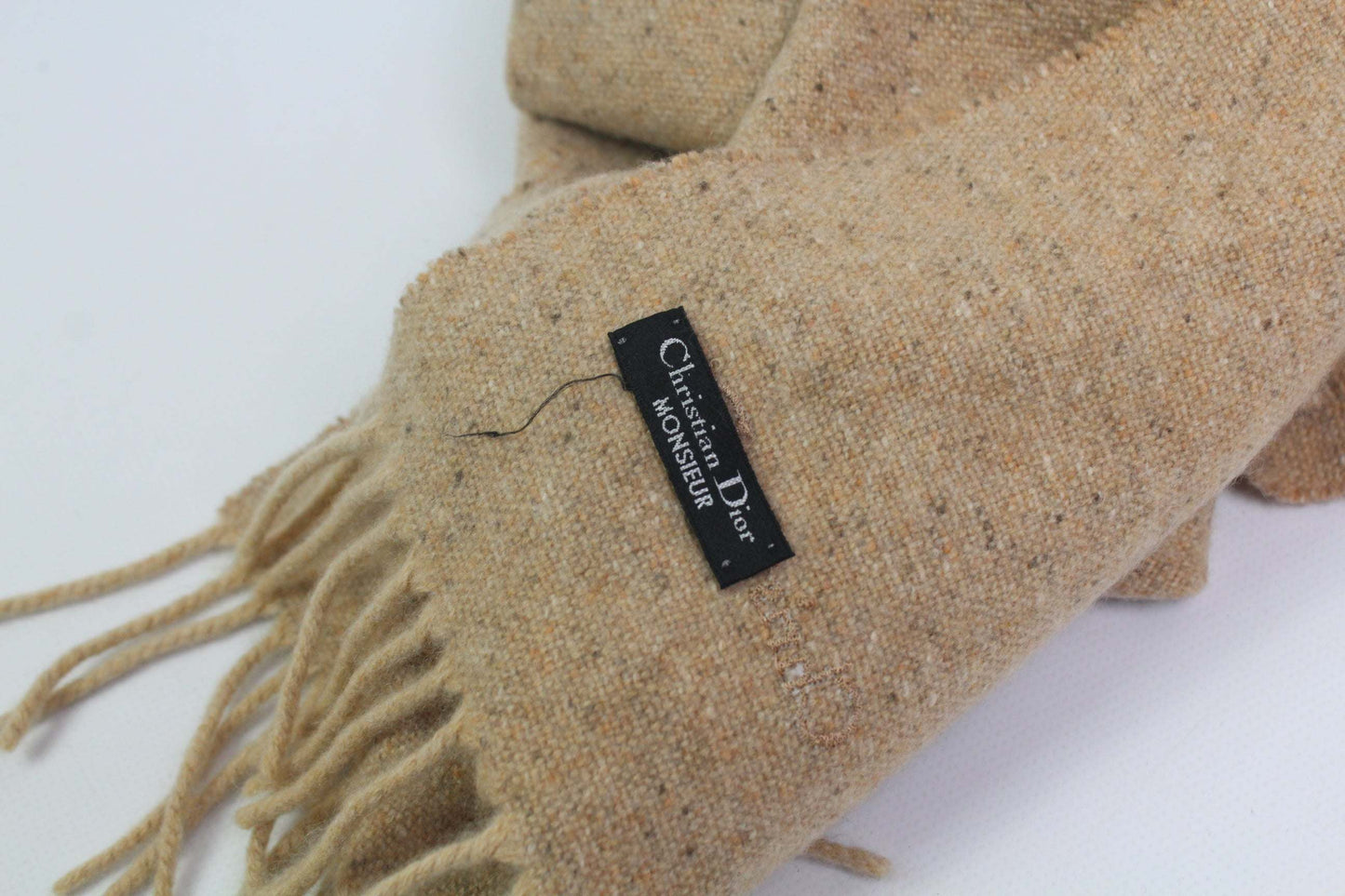 Beige DIOR muffler with fringe detail and label.