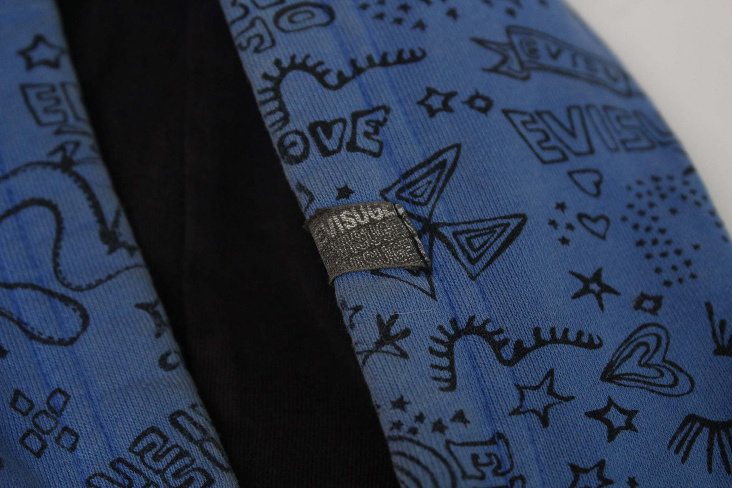 Blue EVISU hoodie with black graphic design and fabric label.