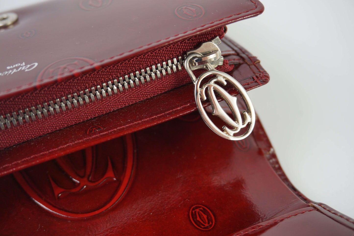 CARTIER Leather Longwallet Bordeaux in red leather with zipper detail.