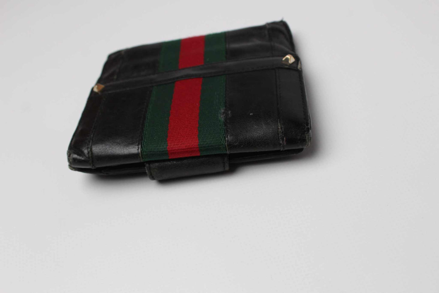 Black GUCCI wallet with red and green stripe, fabric and leather material.