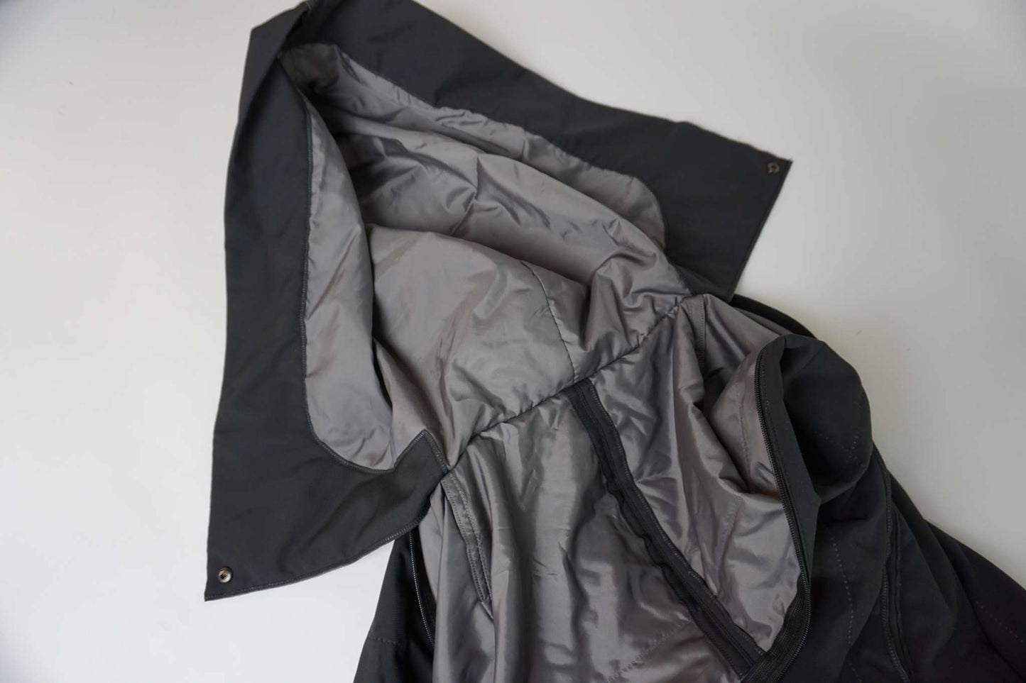 Black ISSEY MIYAKE trenchcoat showing grey interior, size M, condition 8/10.