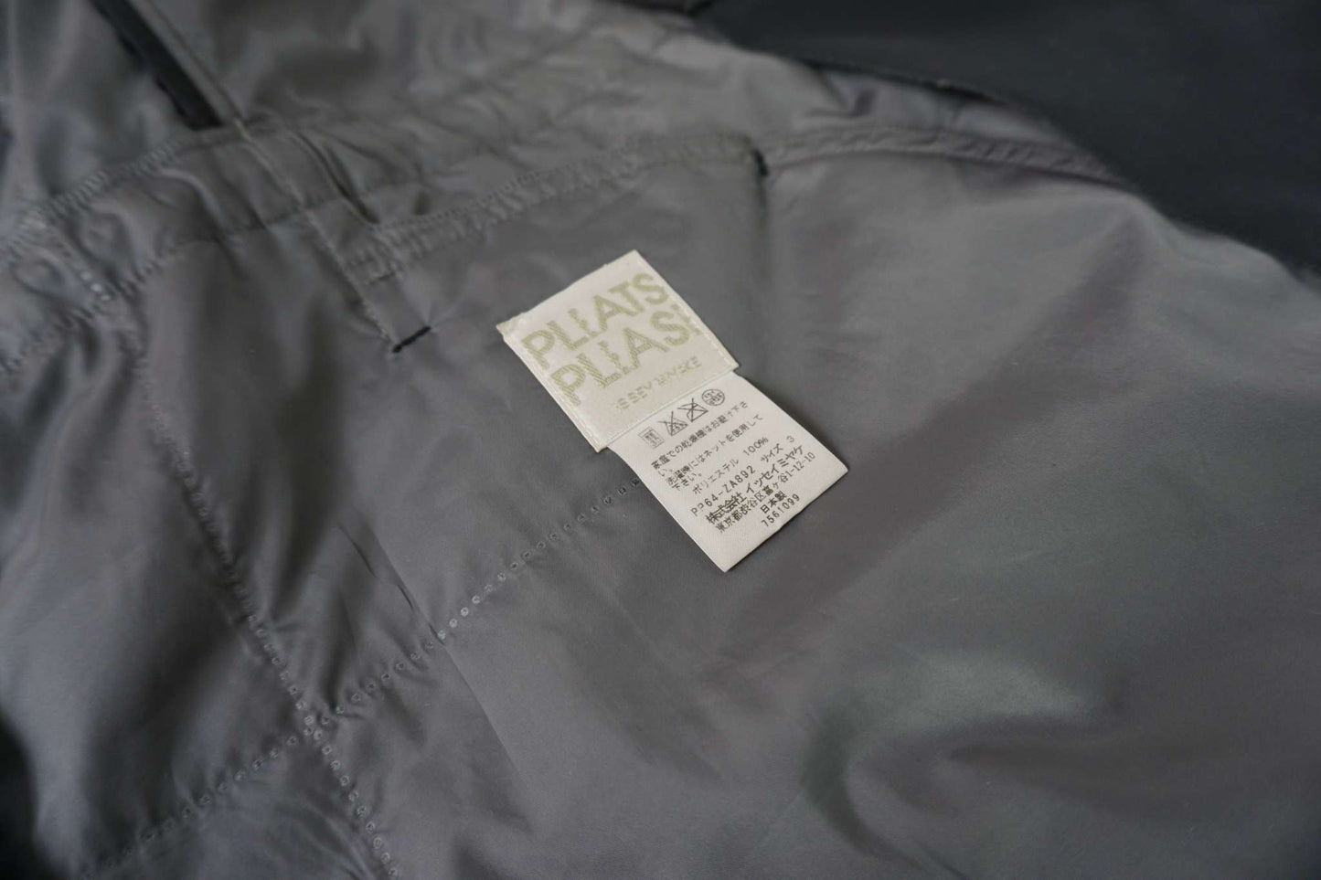 ISSEY MIYAKE black trenchcoat, size M, gray color, 8/10 condition, label detail visible.