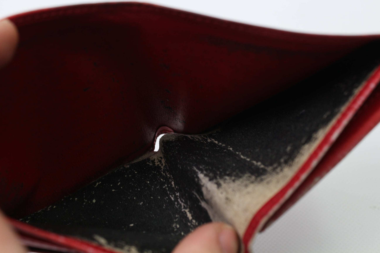 Interior view of the red LOUIS VUITTON Epi Portemonnaie with visible wear.