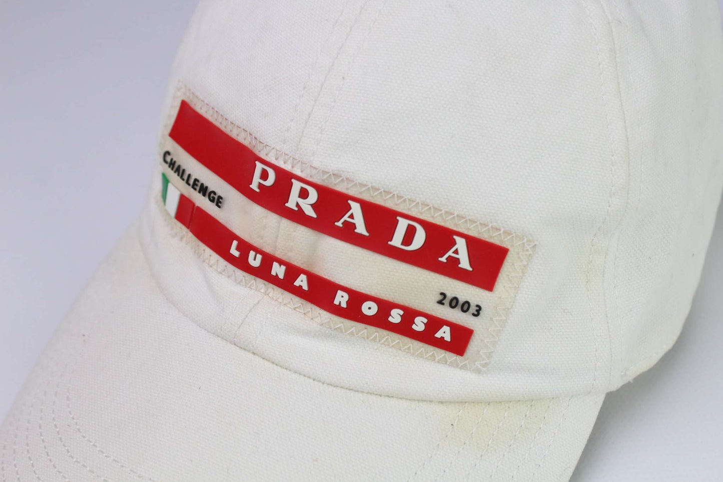 White PRADA Luna Rossa Cap with red logo detailing.