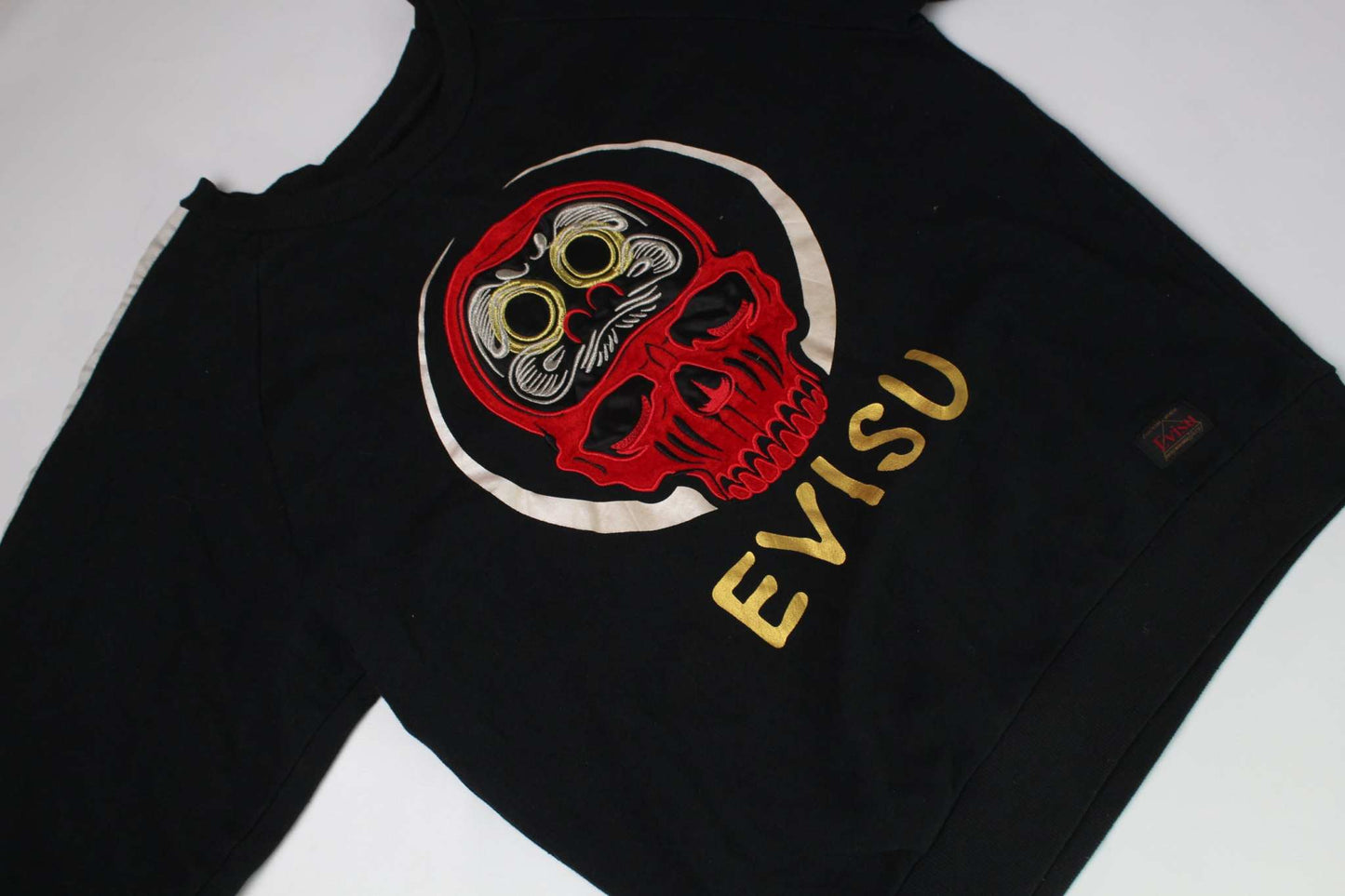 Black EVISU crewneck sweater with red skull design.