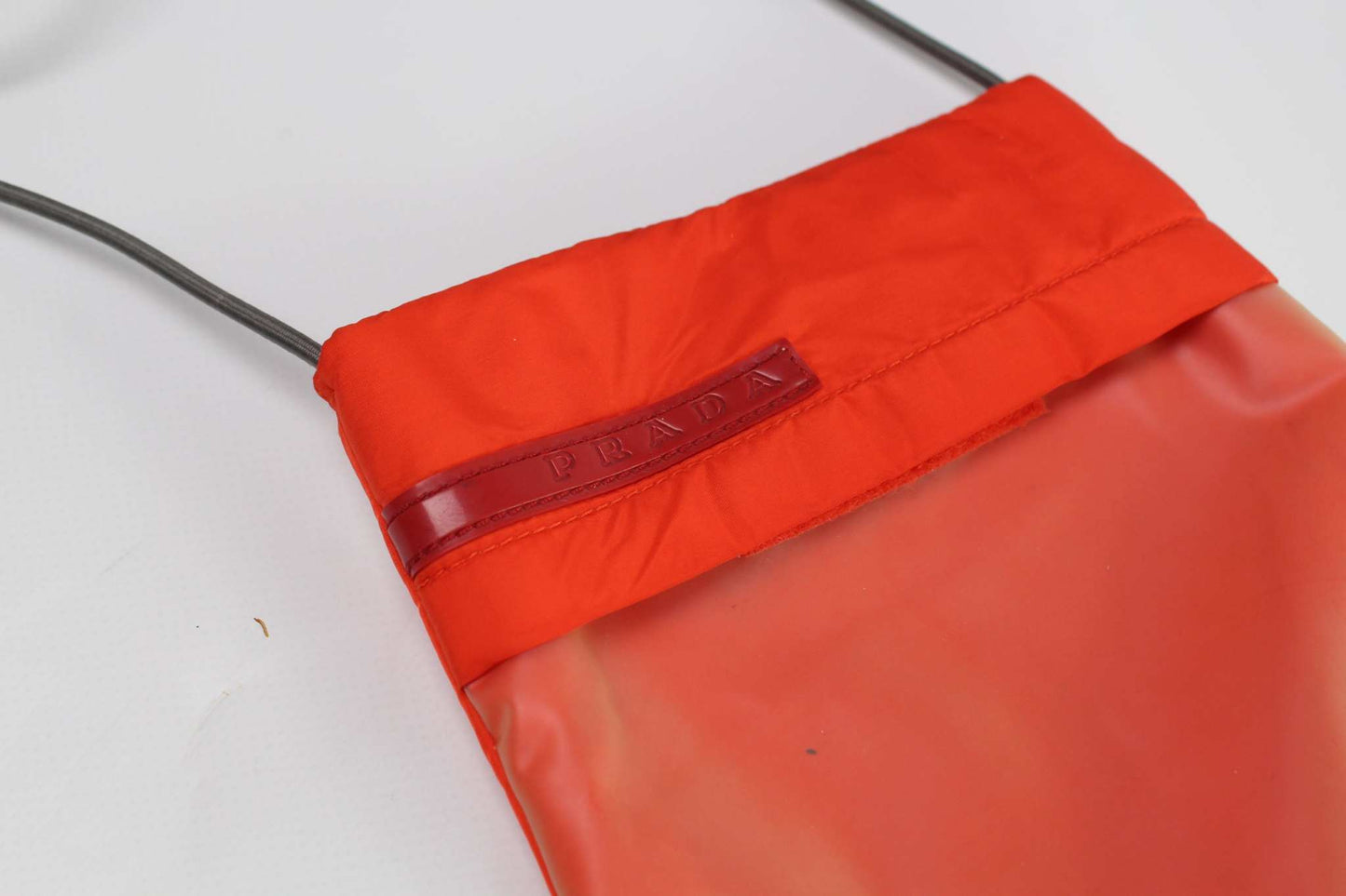 PRADA Sports Slingbag in orange nylon with elastic rubber bands.