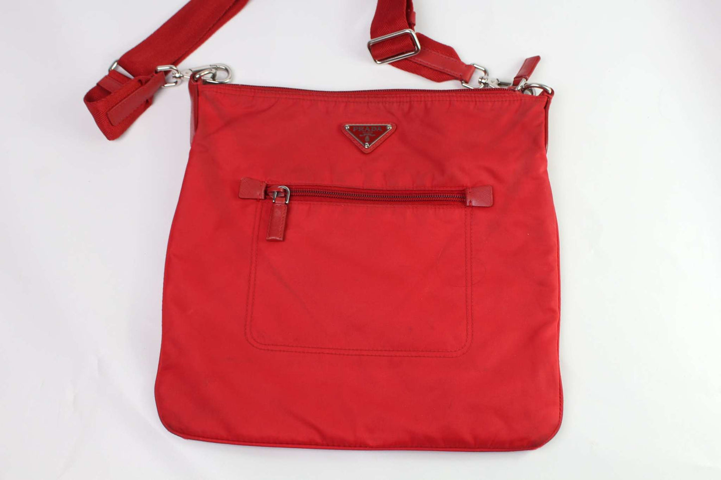 PRADA red slingbag with zipper and nylon material.