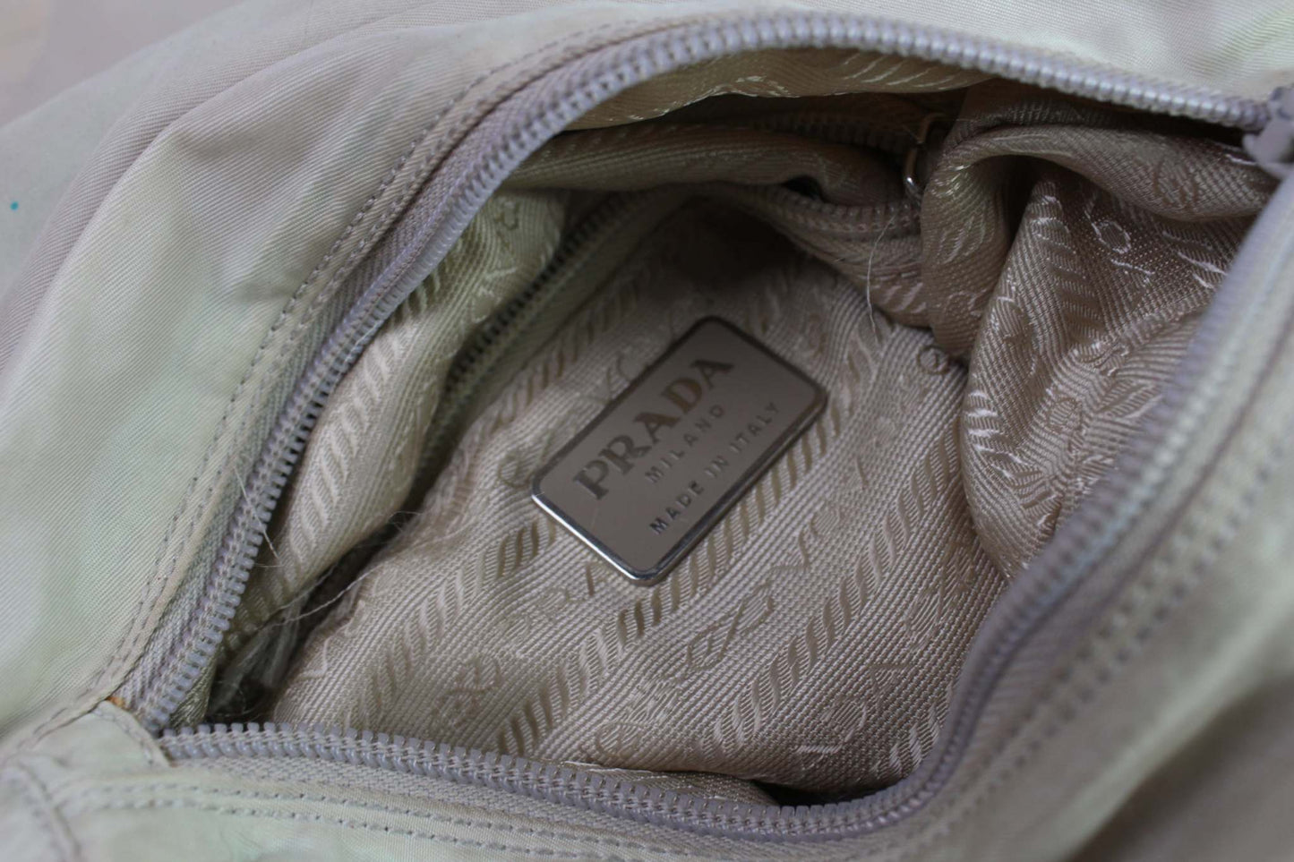 PRADA Messenger Bag White interior view with Prada logo and beige lining.