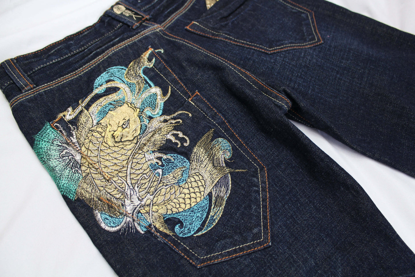 BIG TRAIN Koi embroidery denim jeans with colorful back pocket design.