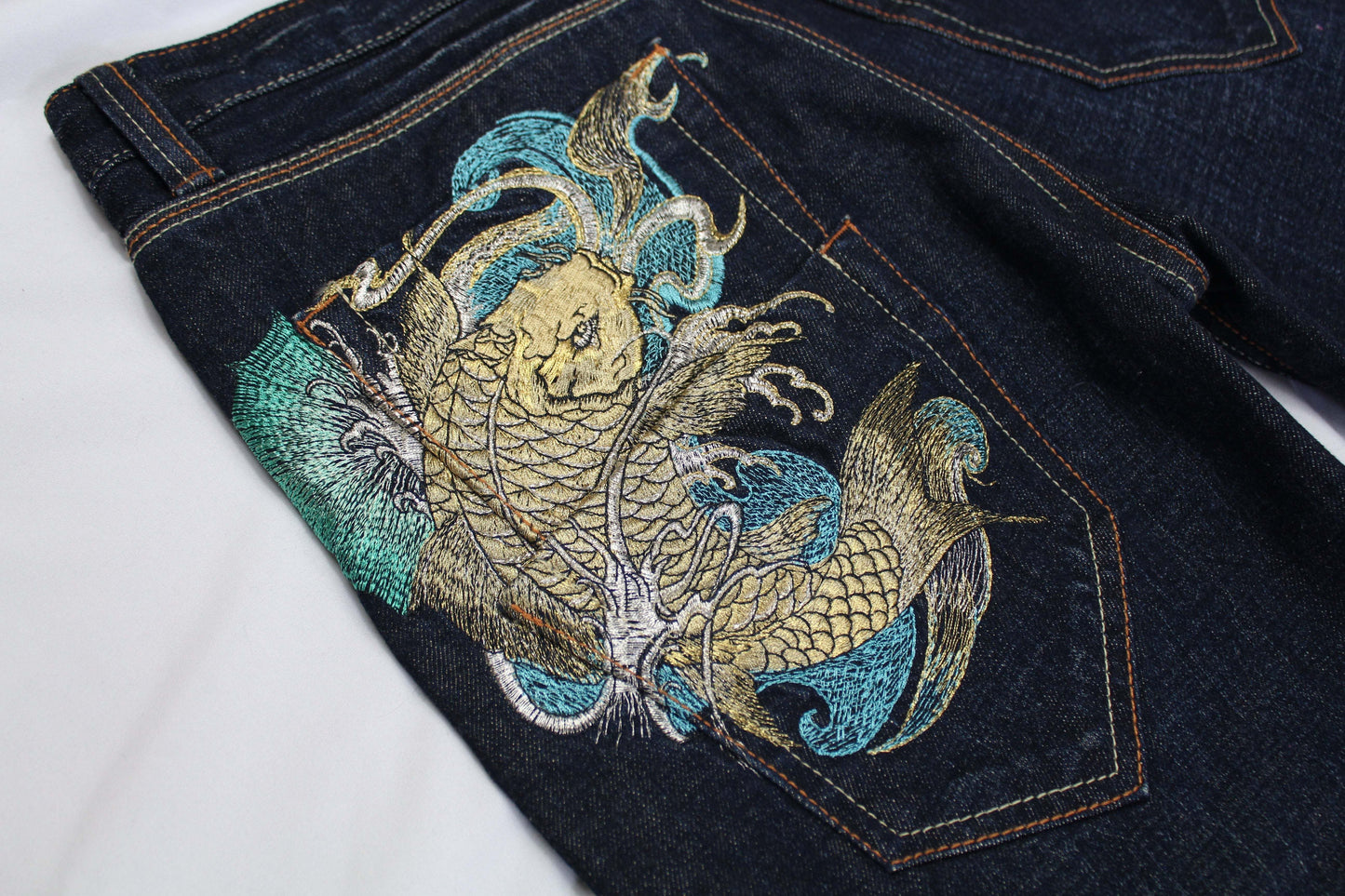 BIG TRAIN Koi embroidery denim with colorful stitching on back pocket.