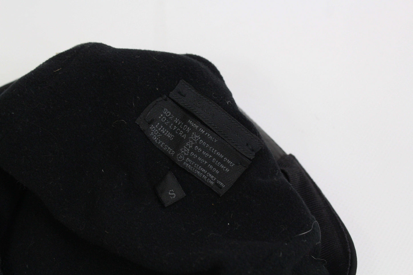 Close-up of a black PRADA cap label and interior.