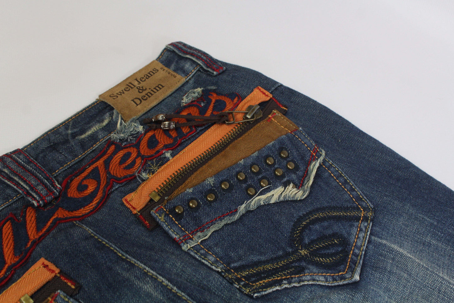 SWELL JEANS Embroidery Flared Denim with orange detailed stitching and studded pocket.