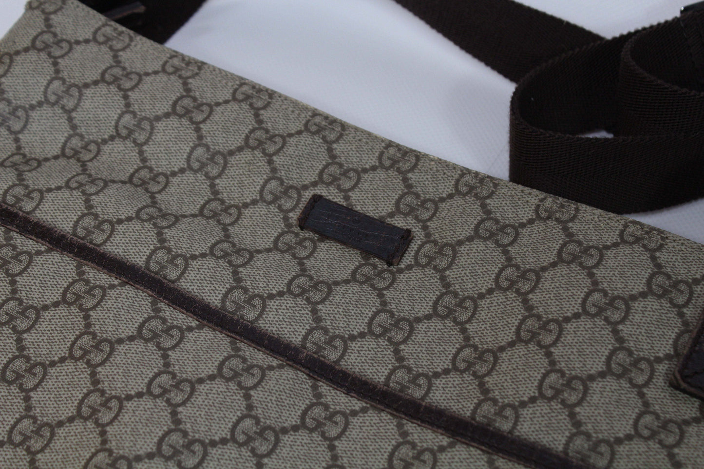 GUCCI Slingbag Monogram Brown canvas with signature pattern, side view.