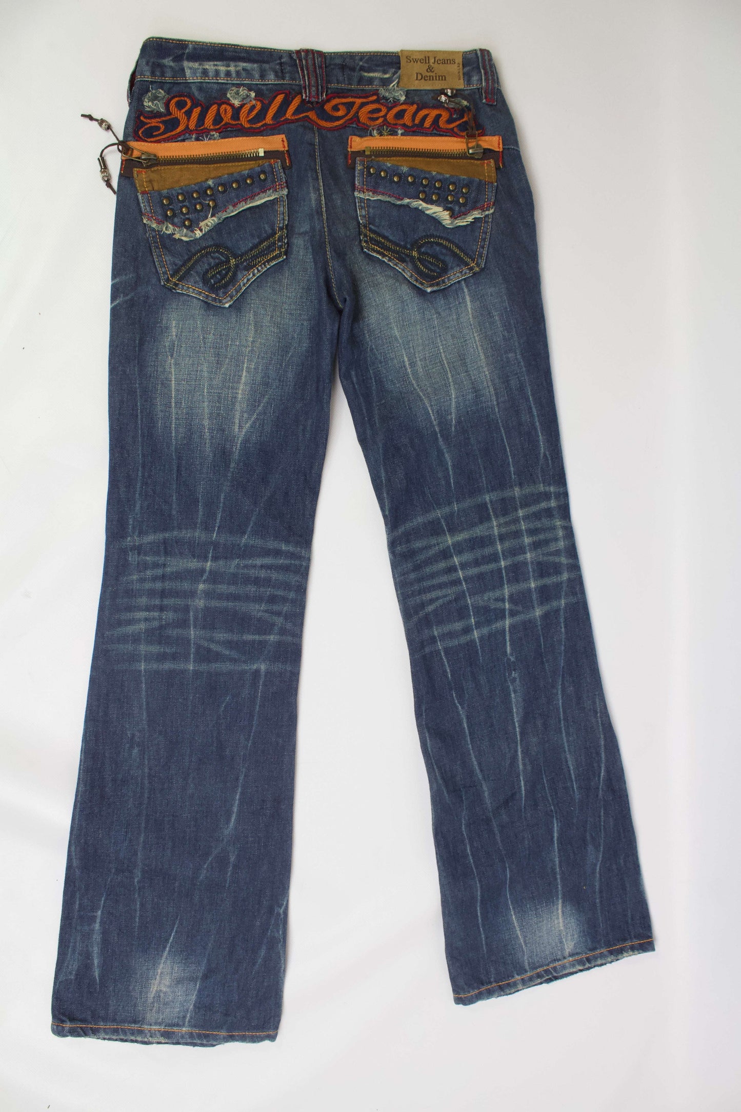 Flared denim jeans with orange embroidery and blue color, featuring back pocket design.