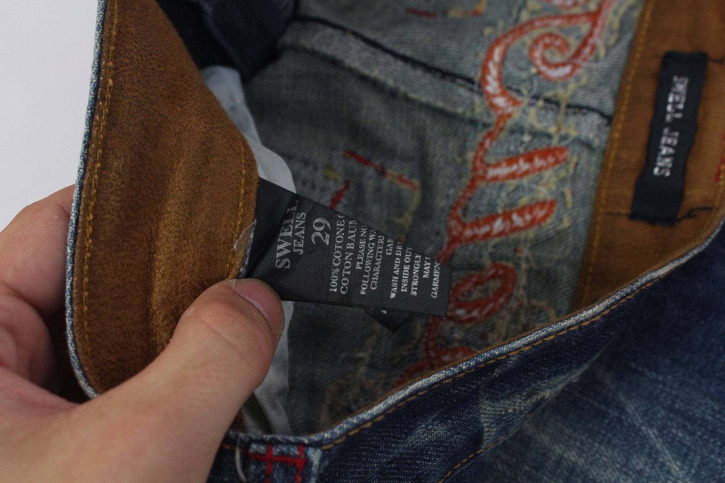 SWELL JEANS embroidery flared denim in blue and orange with cotton material and size tag details.