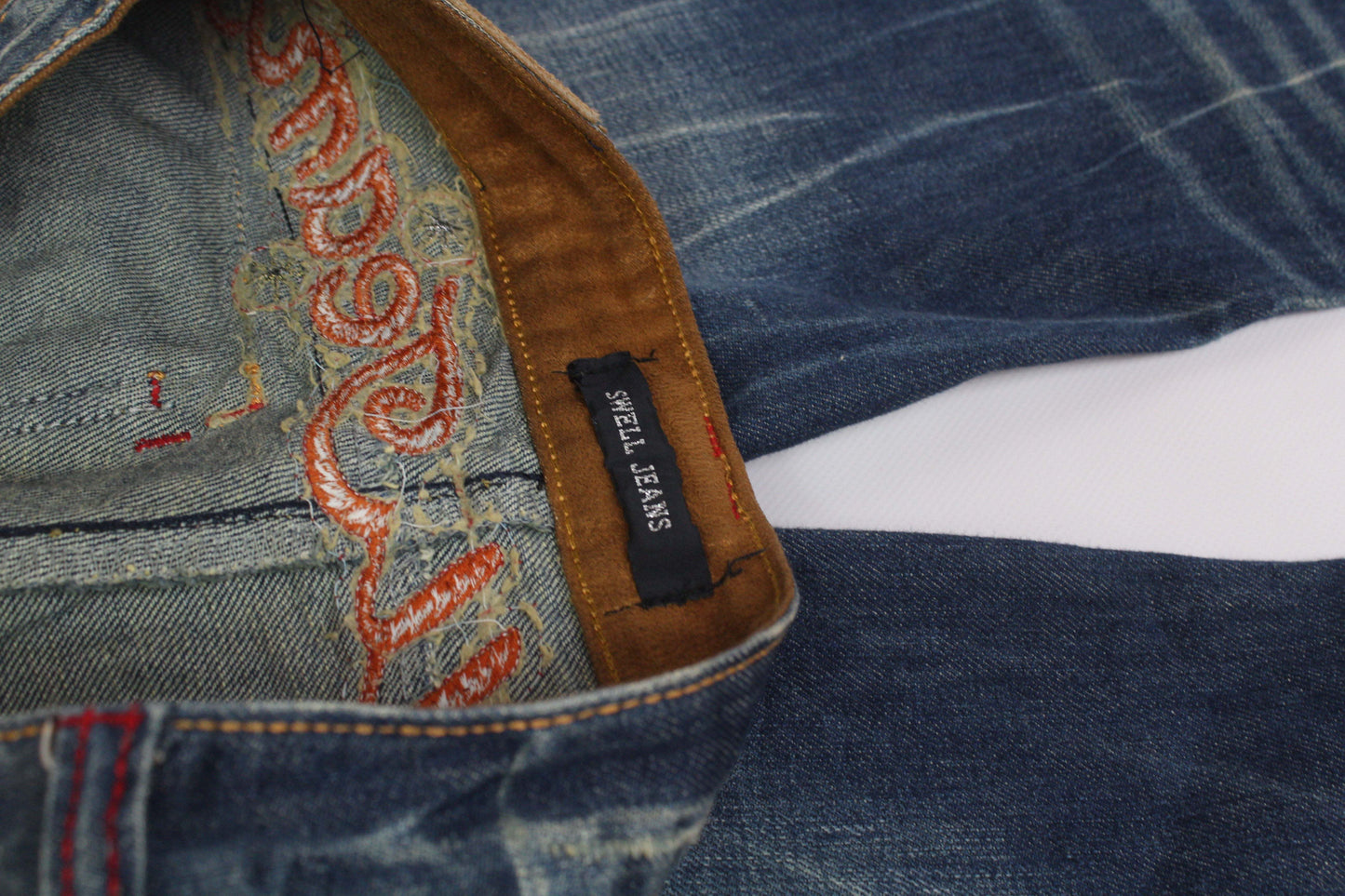 SWELL JEANS Embroidery Flared Denim in blue and orange cotton fabric showing interior detailing.