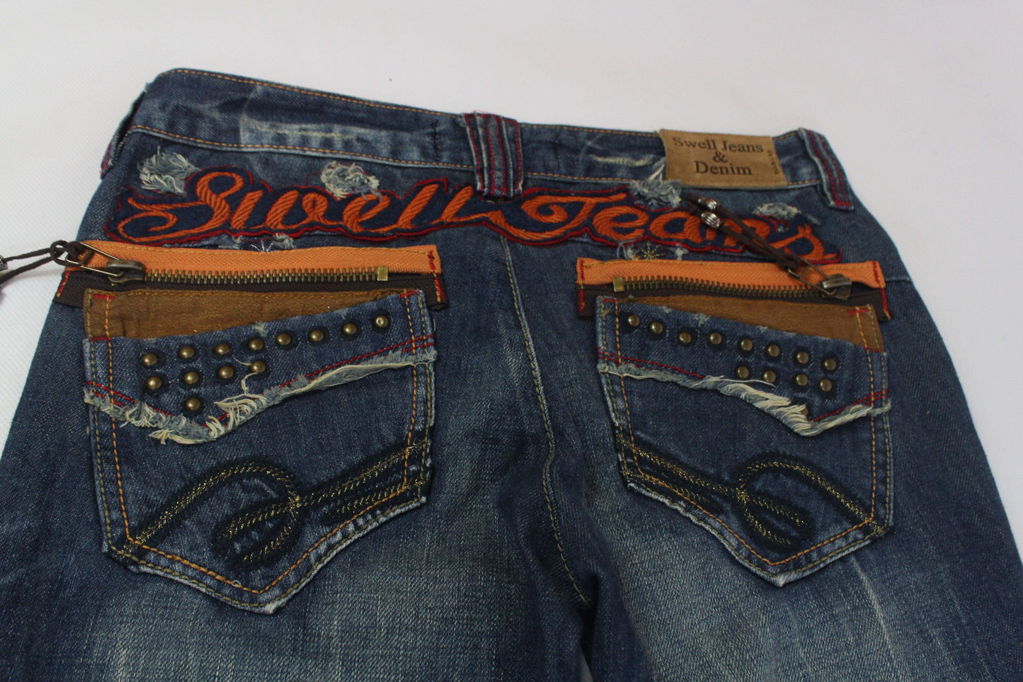 SWELL JEANS Embroidery Flared Denim in blue and orange with studded back pockets.