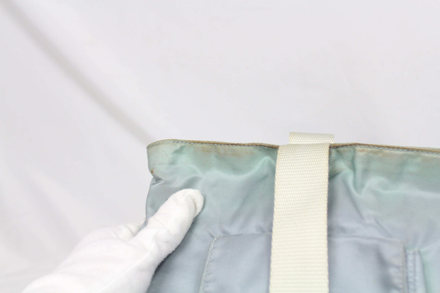 Prada Shopper Babyblue Side Emblem with visible wear on edge.