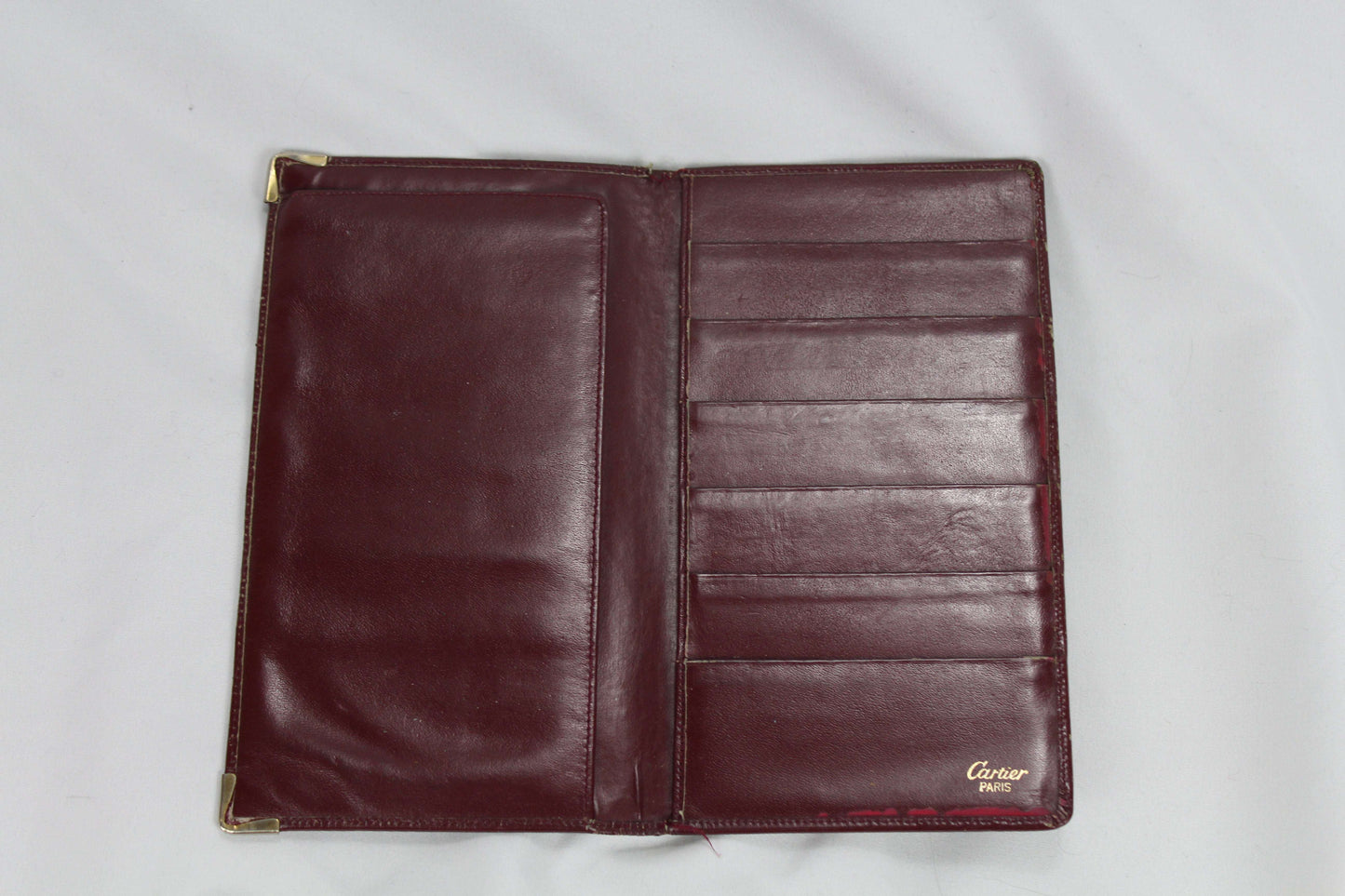 Burgundy Cartier wallet in good condition with multiple card slots.