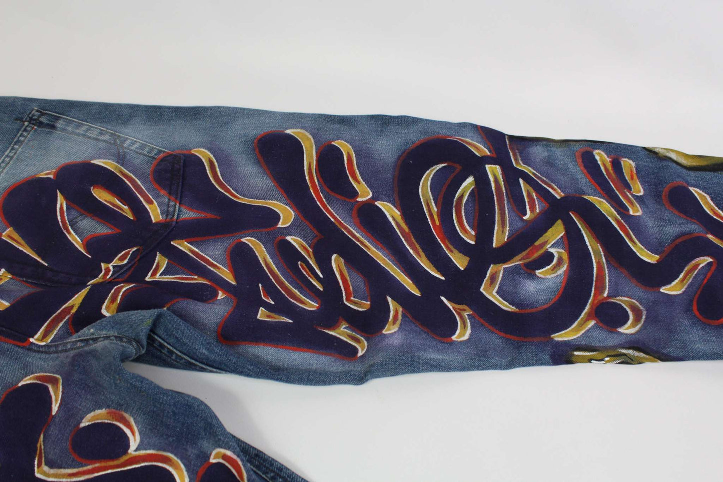 Denim hand painted custom jeans with colorful graffiti-style design.