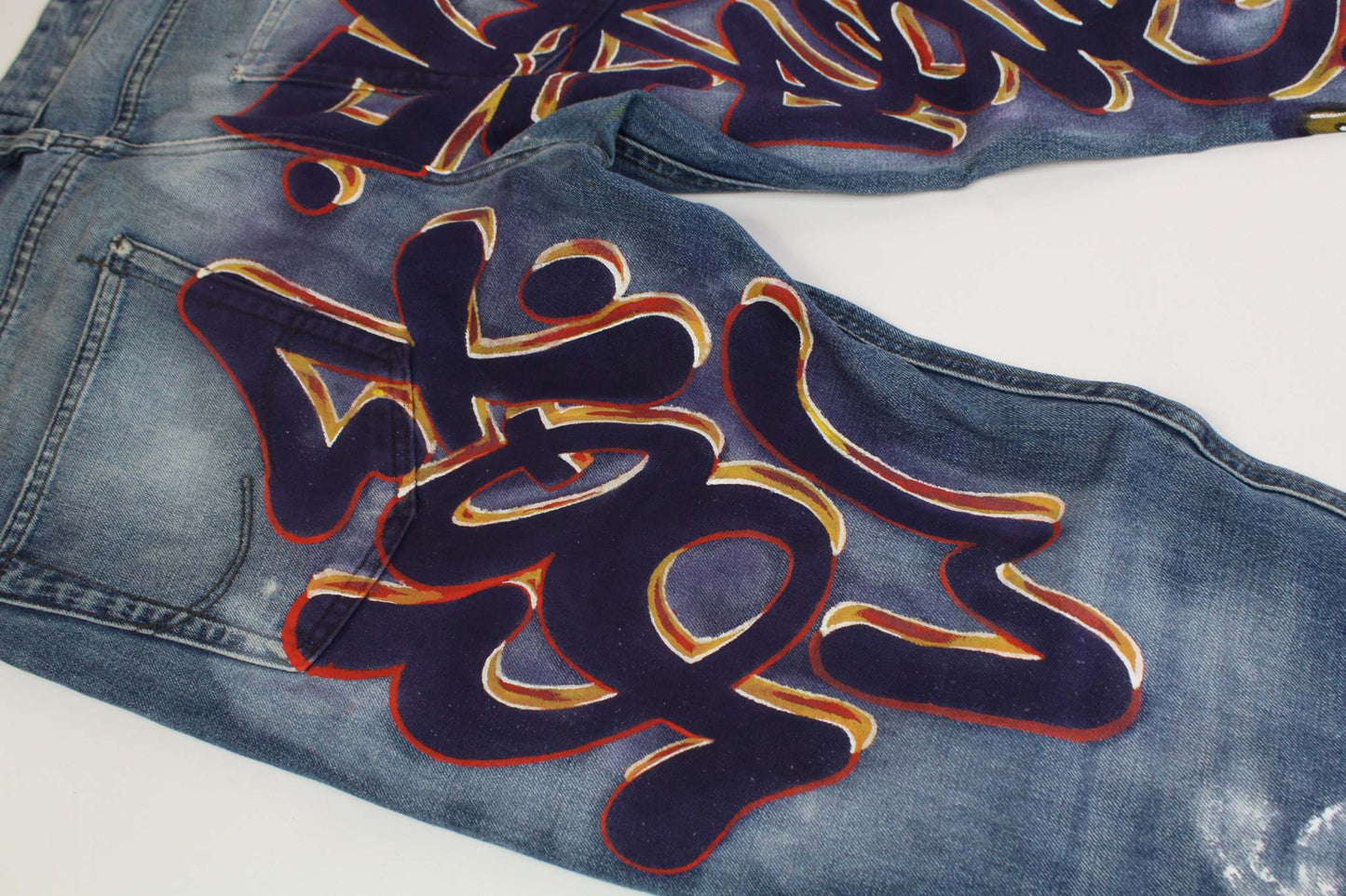 Hand-painted custom denim with blue graffiti design, straight fit, size 31/34, waterproof paint.