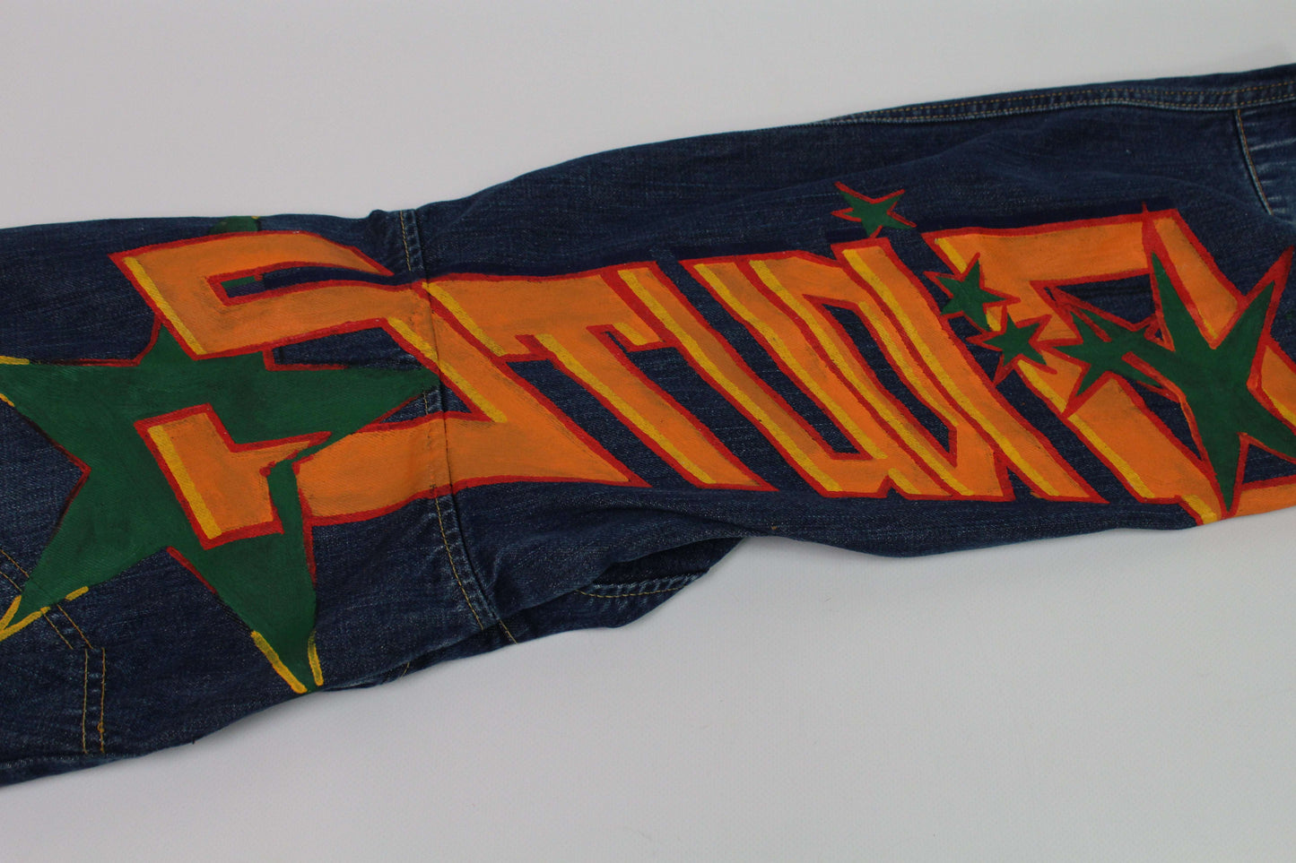 Custom painted G-Star jeans featuring bold orange and green artwork, size 32x32, straight fit, blue cotton.