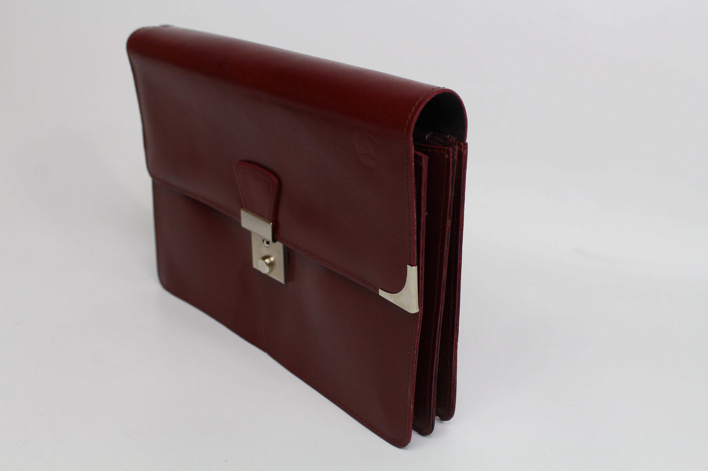 Vintage Mercedes clutch in Bordeaux leather with slight wear, condition 8/10.