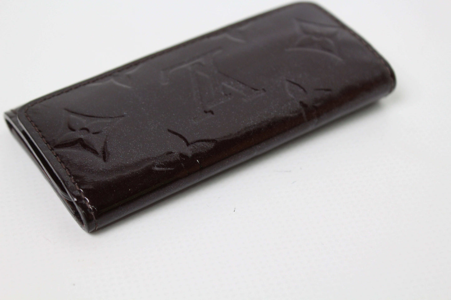 LOUIS VUITTON Keyholder Vernise Bordeaux in leather with embossed design, 5x10cm.