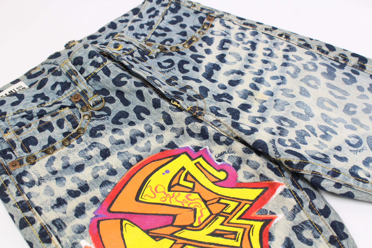 Custom painted jeans with blue and black leopard print and colorful graffiti design.