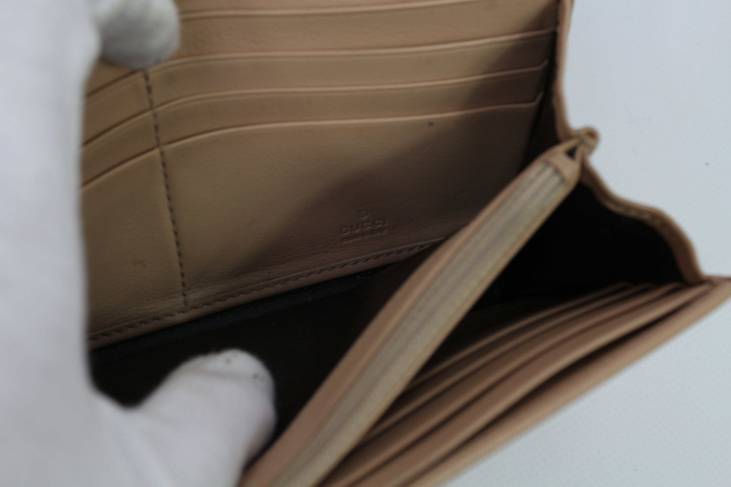 Beige Gucci long wallet with heart design and multiple card slots.