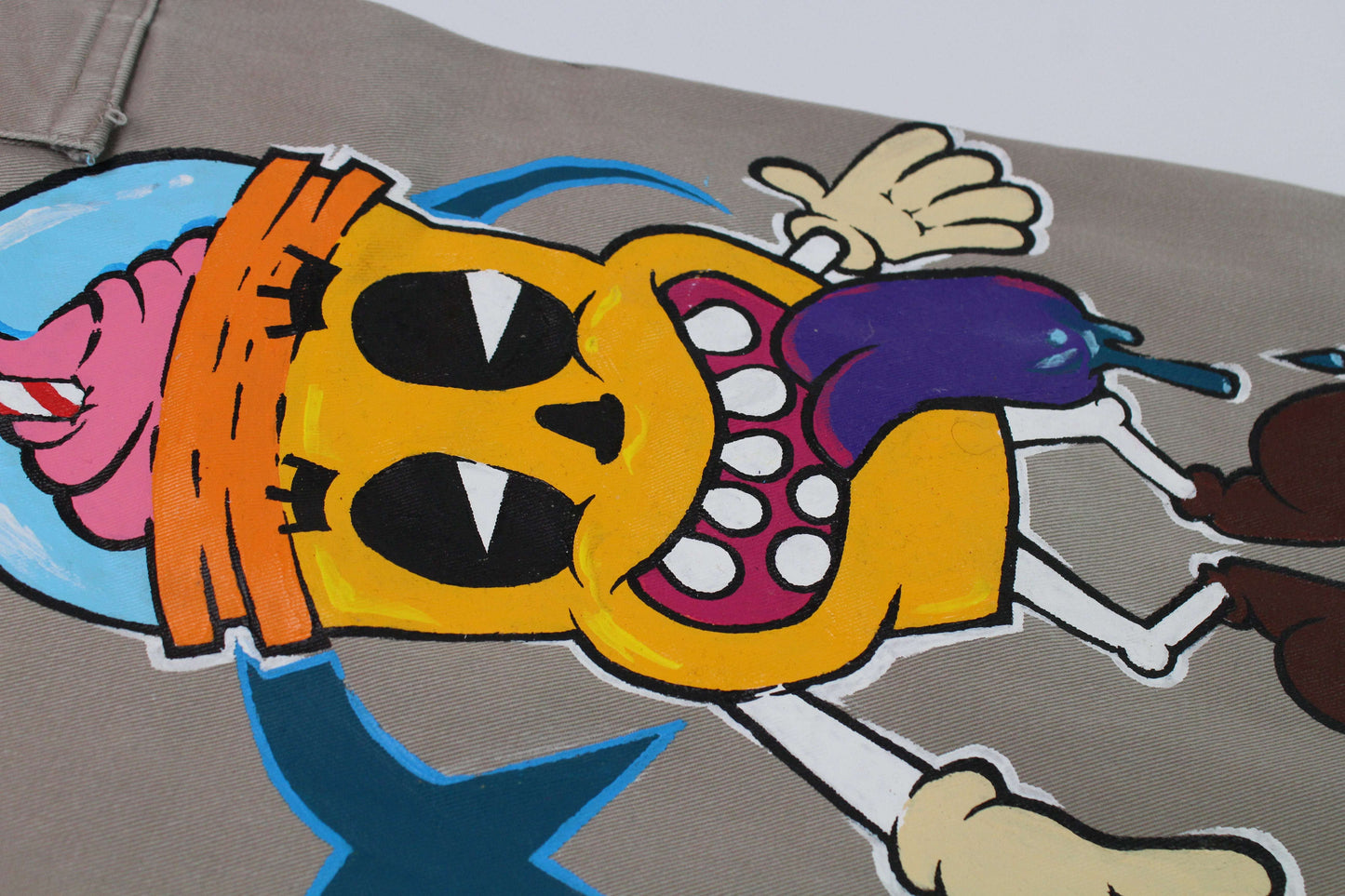 Custom Painted Jeans 1 - 1 featuring colorful cartoon artwork on beige cotton fabric.