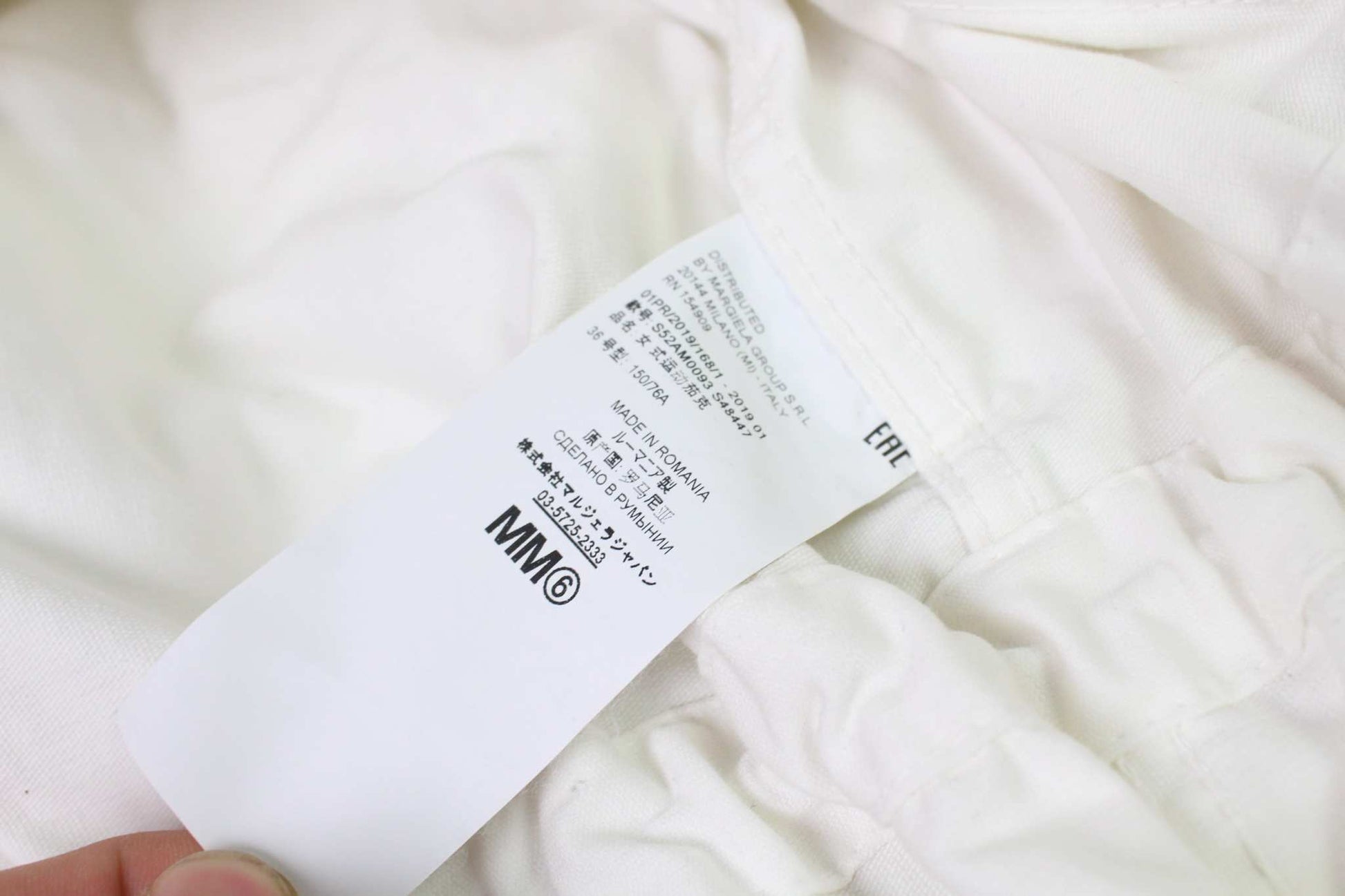 MAISON MARGIELA MM6 white jacket label showing size and care instructions.