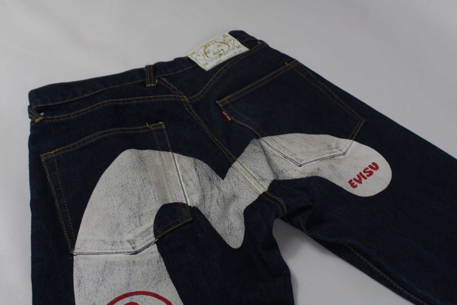 EVISU Daicock White denim jeans in blue with large logo on back.