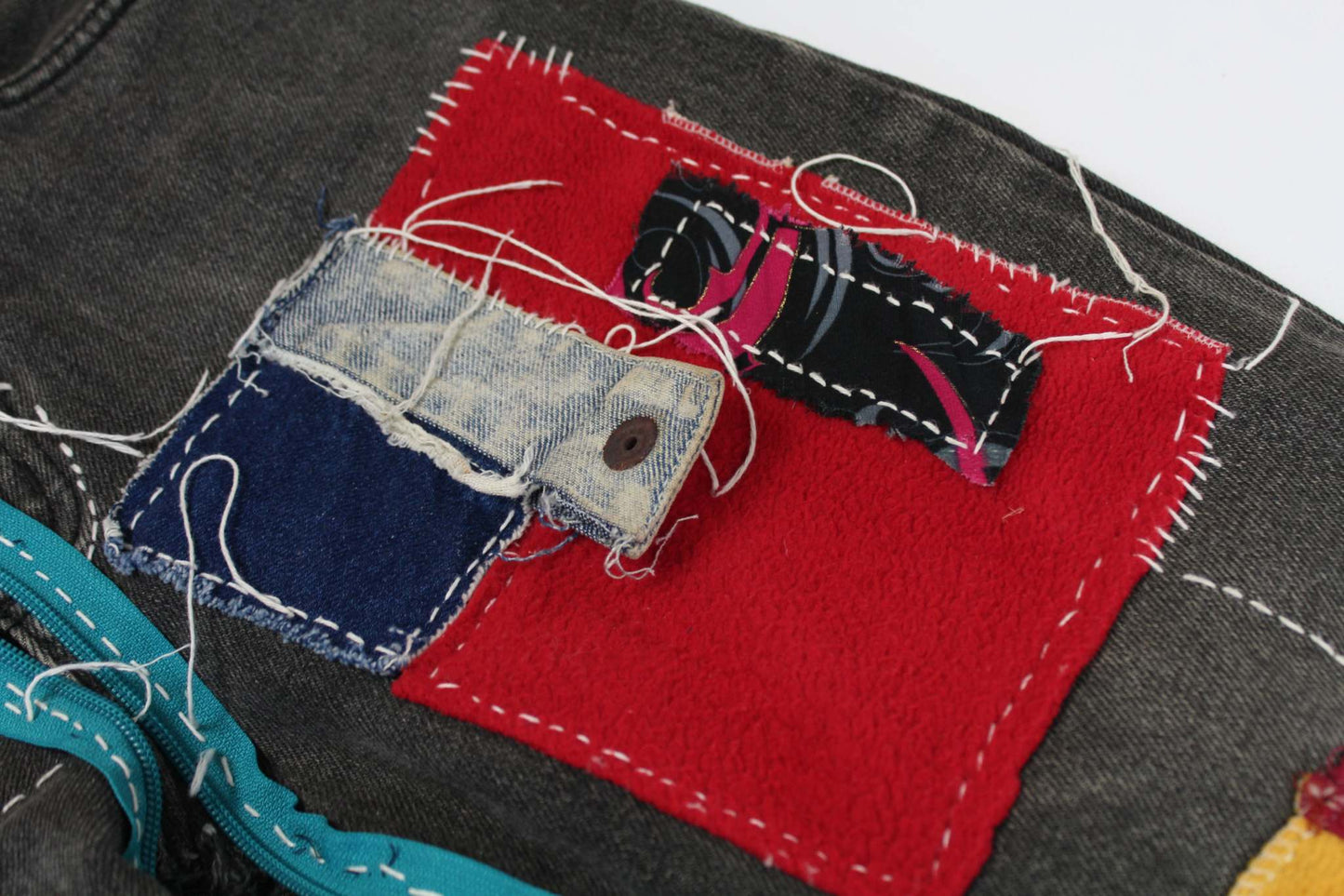 Close-up of Costarica&Jeans Patchwork Denim with colorful patchwork and detailed stitching.