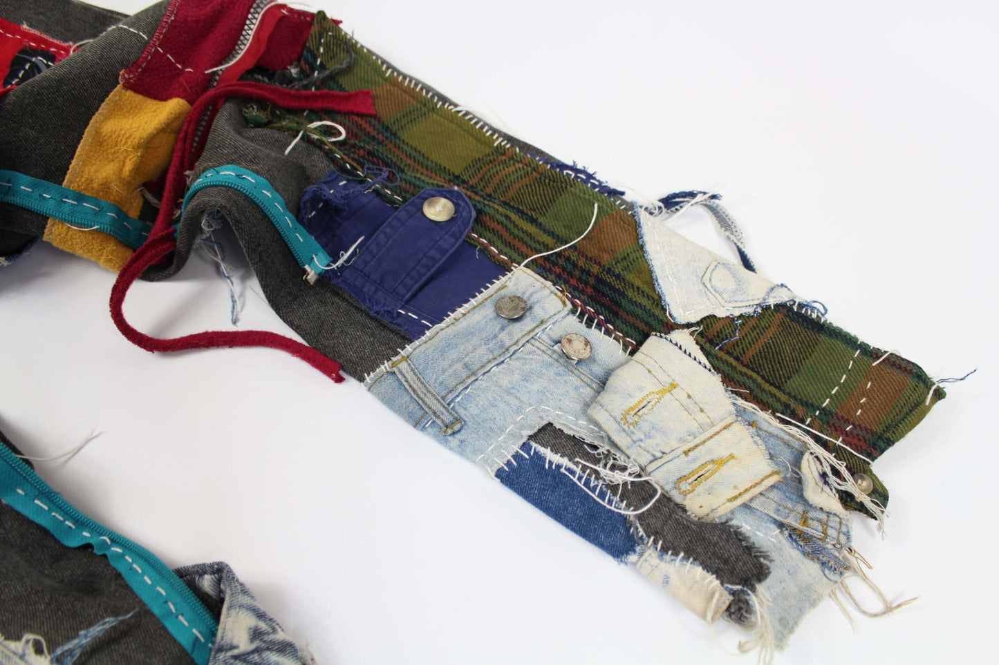 Colorful patchwork detail of CostaRica Jeans Patchwork Denim, featuring various fabric textures and stitch patterns.