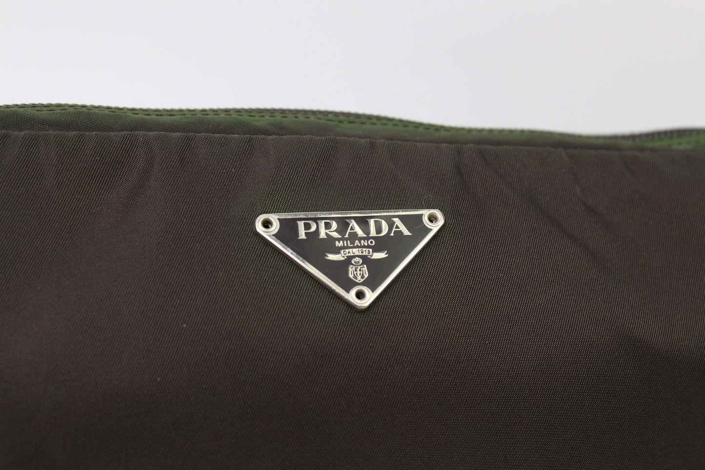 PRADA Clutch Khaki, nylon material, close-up of logo tag.