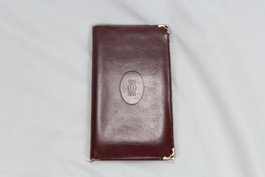 Brown Cartier wallet with metal corner accents.