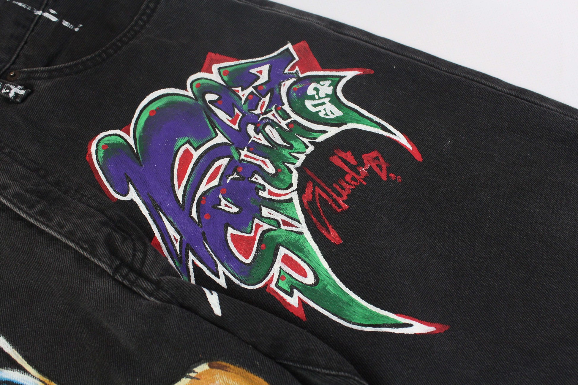 Edwin denim with custom hand-painted graffiti design, black/grey color, straight fit.