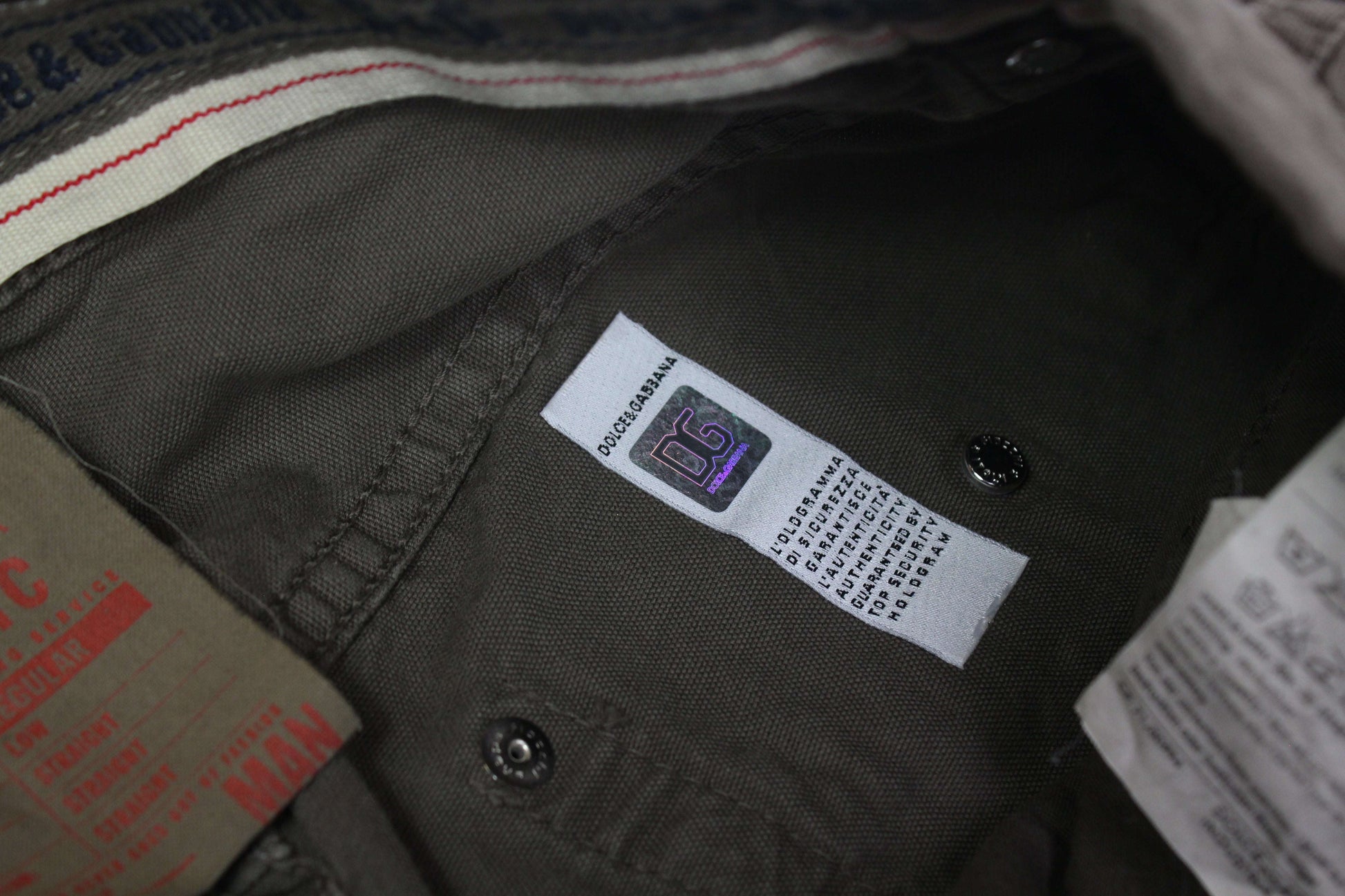 Dolce & Gabbana pants label in grey/green fabric with visible brand tag.