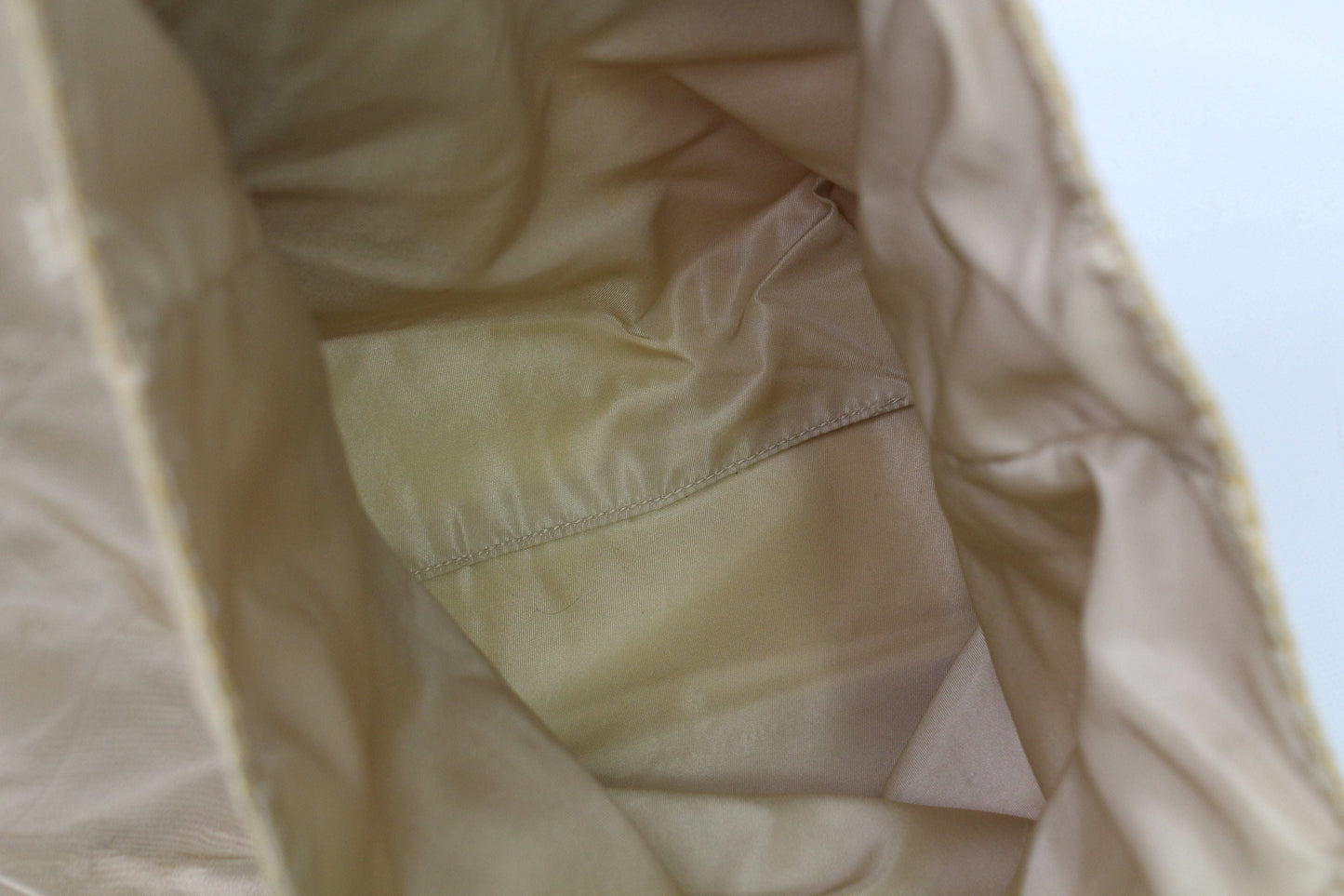 Close-up of the interior of a Prada Shopper Gold bag in beige/gold color, showing slight wear marks.