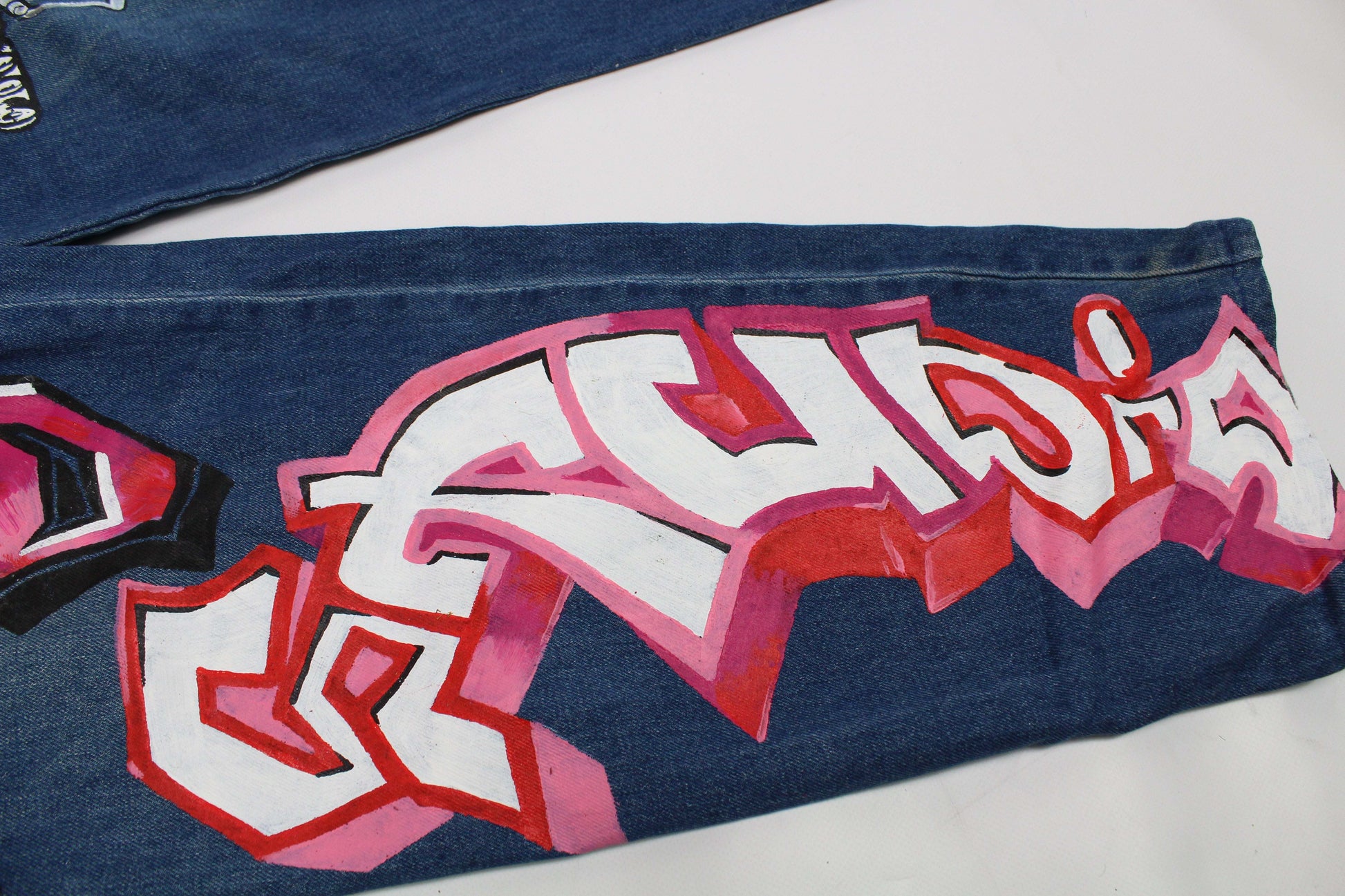 Custom painted jeans with graffiti art in blue and white, size 32x34, straight fit, made of cotton.