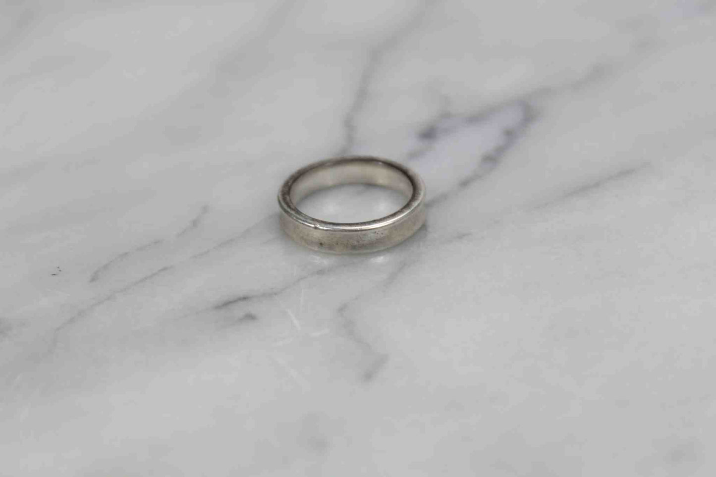 Tiffany Ring 925 with slight scratches on marble background.