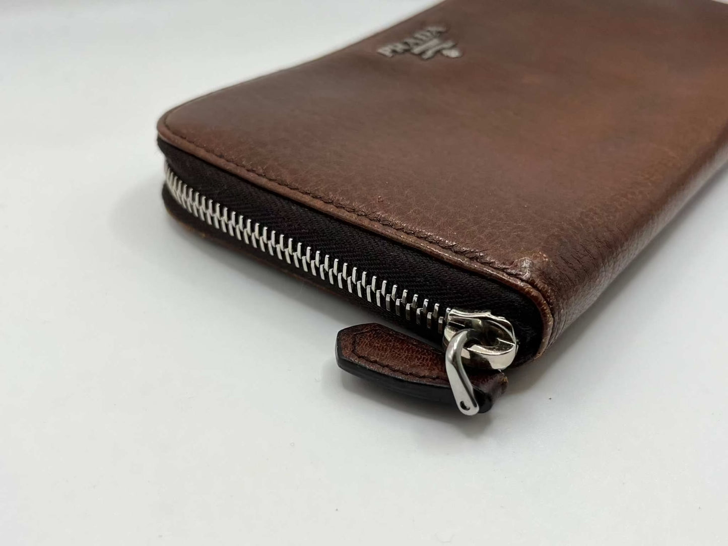 PRADA leather longwallet in brown with zipper detail.